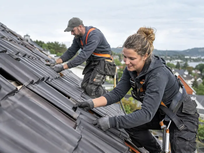 Handwerker bei der Arbeit auf einem Ziegeldach